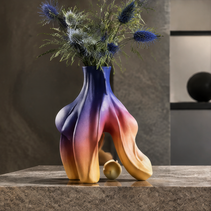 Organic flame vase with gradient glaze on stone surface — full lifestyle scene with blue thistle flowers