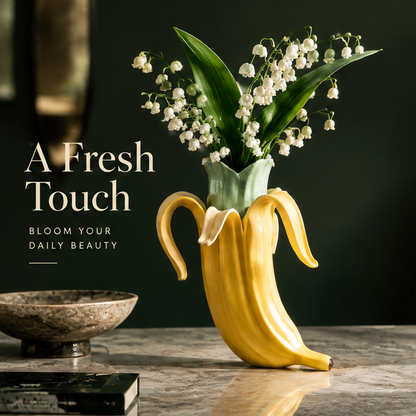 Peeled banana ceramic vase with green inner sleeve and glossy glaze on stone surface with lily of the valley bouquet
